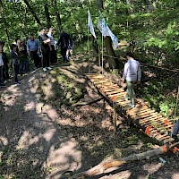 Team läuft über selbst gebaute Brücke