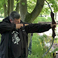 Mann schießt mit Pfeil und Bogen