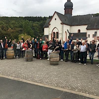 Gruppenfoto vom Teambuilding mit Fässern im Vordergrund