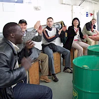 Mehrere Leute klatschen beim Teamtrommeln