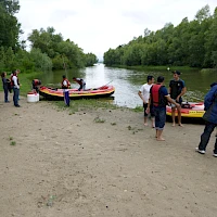 Team mit Kraftbooten am Ufer