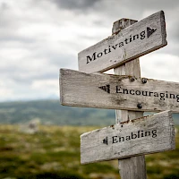 Wegweiser mit der Beschriftung: Motivation, Encouraging und Enabling