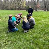 Team hockt auf der Wiese